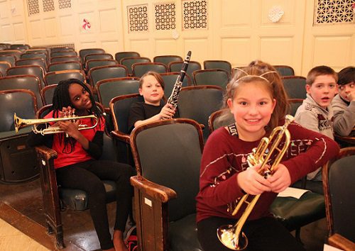 elementary students holding band instruments