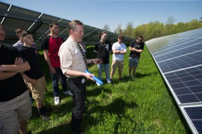 teacher and students discuss energy by solar panels