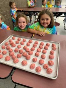 young girls smile with a tray of meatballs
