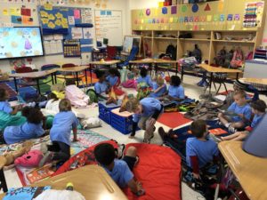 elementary students sit around a pretend camp fire