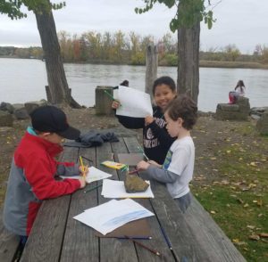 children drawing at a picnic table