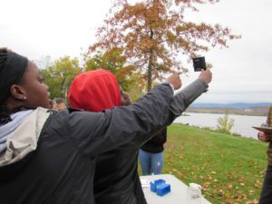 students hold up scientific device to evaluate water samples
