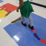 A student demonstrates how to use the sensory path in the first grade hallway.