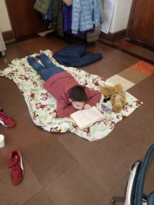 a boy reads on a blanket