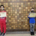 elementary students holding Kindness Certificates