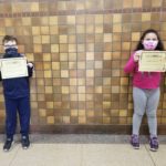 elementary students holding Kindness Certificates