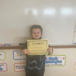 elementary student holding Kindness Certificate