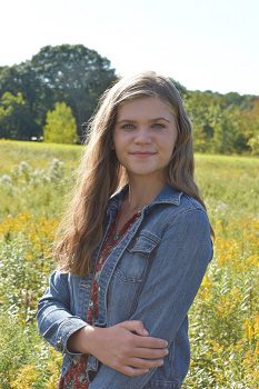 Emma Johnson standing in field of flowers