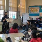 Dr. Lisamarie Spindler reads a book to a fifth grade class