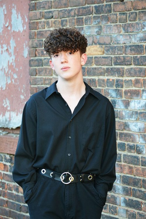 Simon Rowe senior photo taken outdoors in front of a brick wall