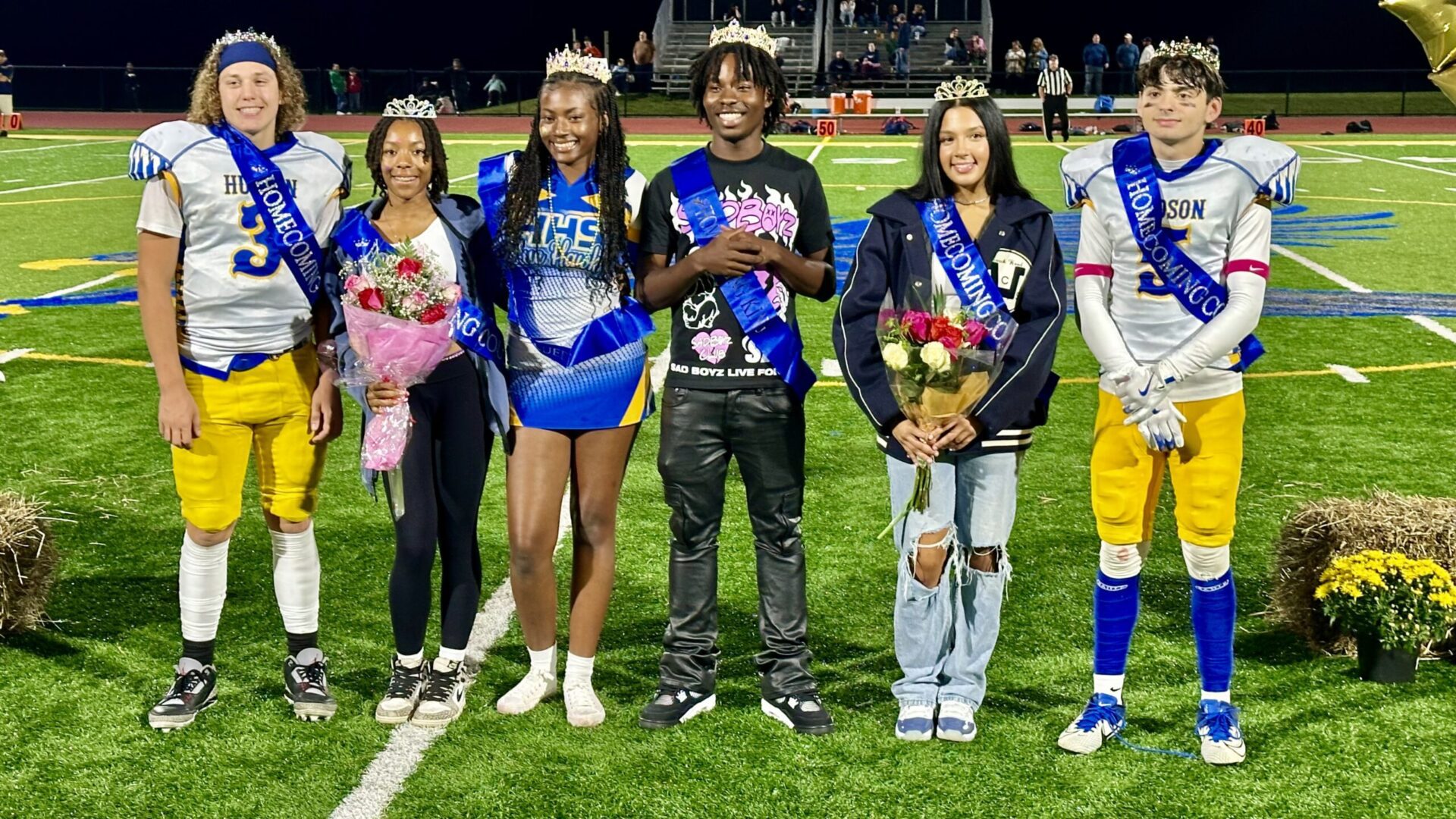 2024 homecoming court standing on the football field