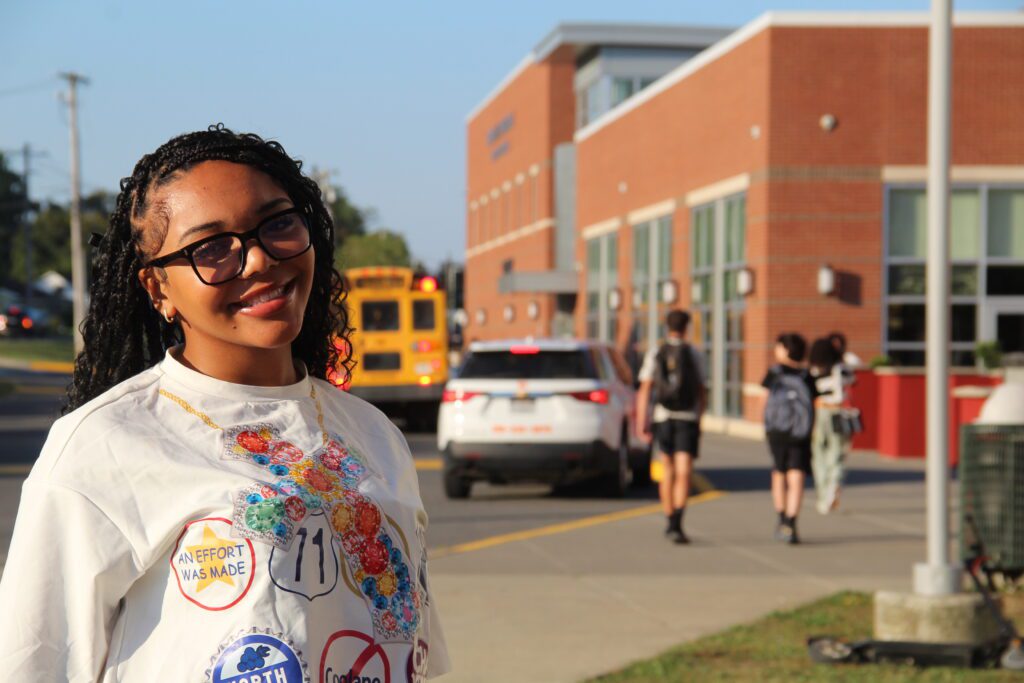 Four teachers looking at one laptop in the art classroom